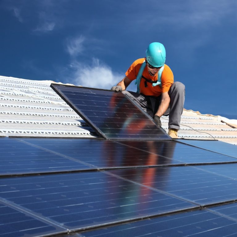 man installing solar panels on the roof