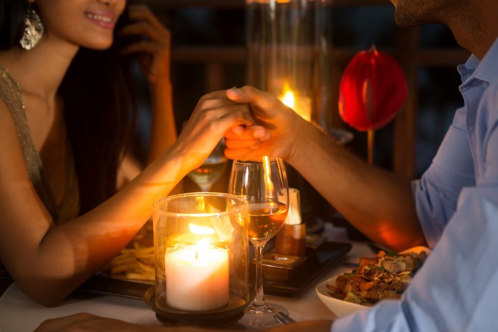 Couple holding hands during romantic dinner