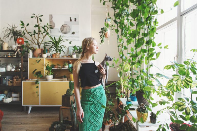Woman standing in her house full of plants