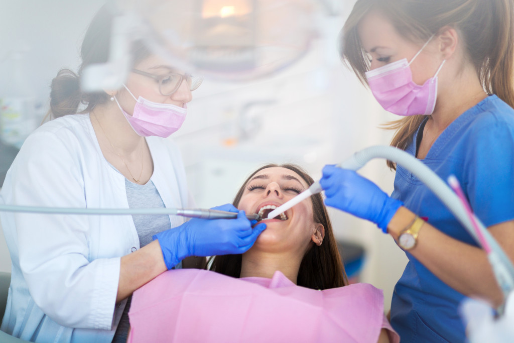 A dentist and her assistant treating a patient