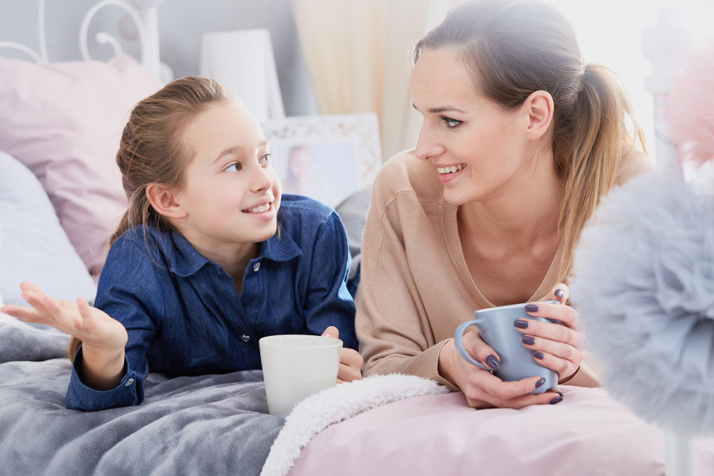 A mother with her daughter talking in bed